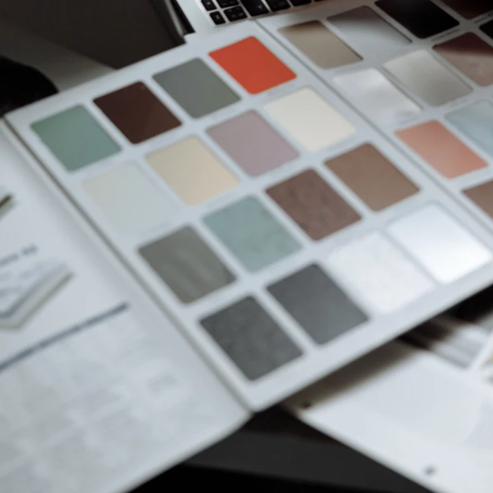 Designer using a colour swatch book beside a laptop