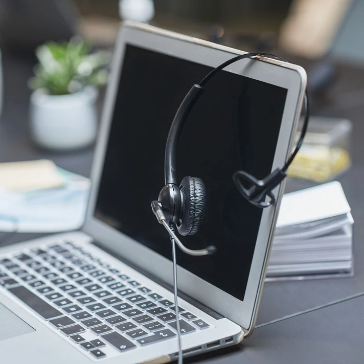 Business headset resting on a laptop for online calls