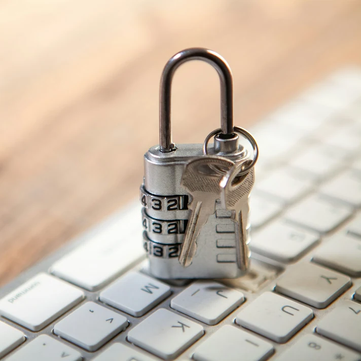 Padlock and keys resting on a real computer keyboard