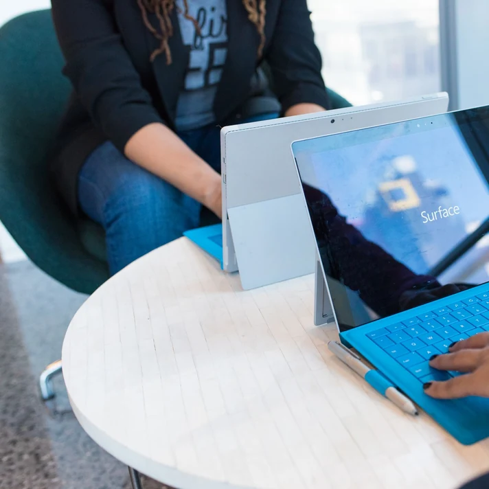 Hands using a Microsoft Surface computer at a work desk