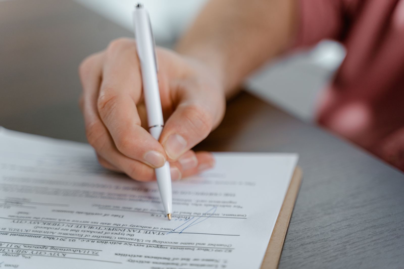 Close-up of a person signing a formal document