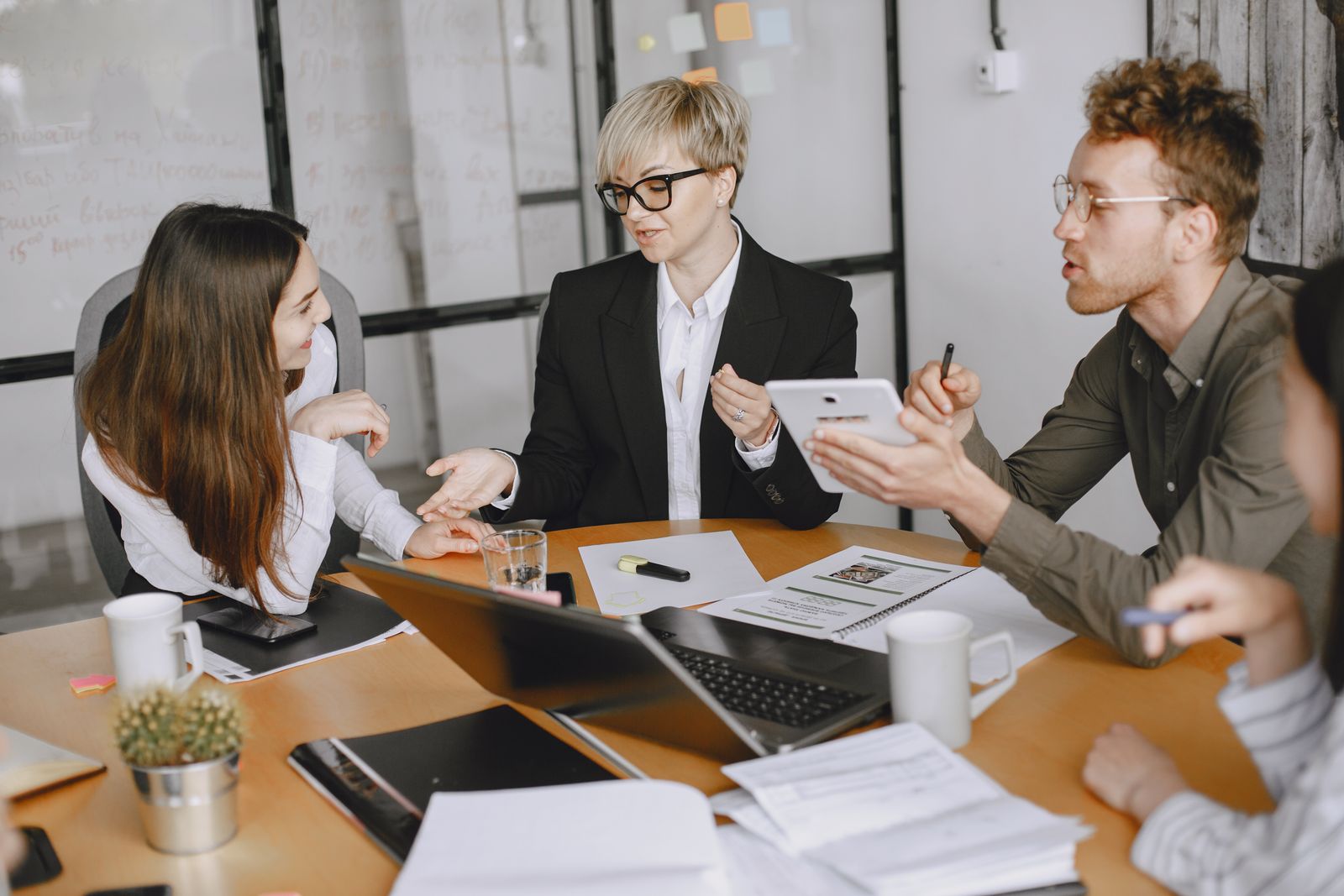 Business partners discussing company records around a meeting table