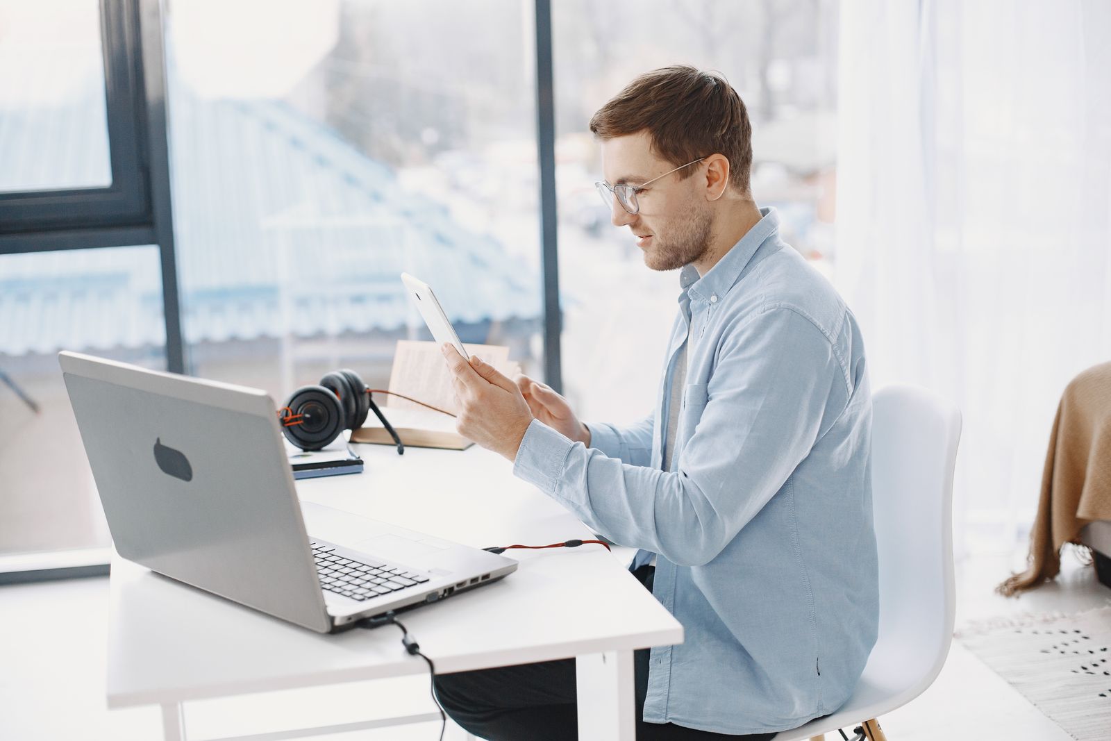 Business owner working at a real office desk with digital devices